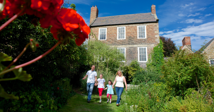 Family ealking through the gardens at Crook Hall Gardens on a bright sunny day.